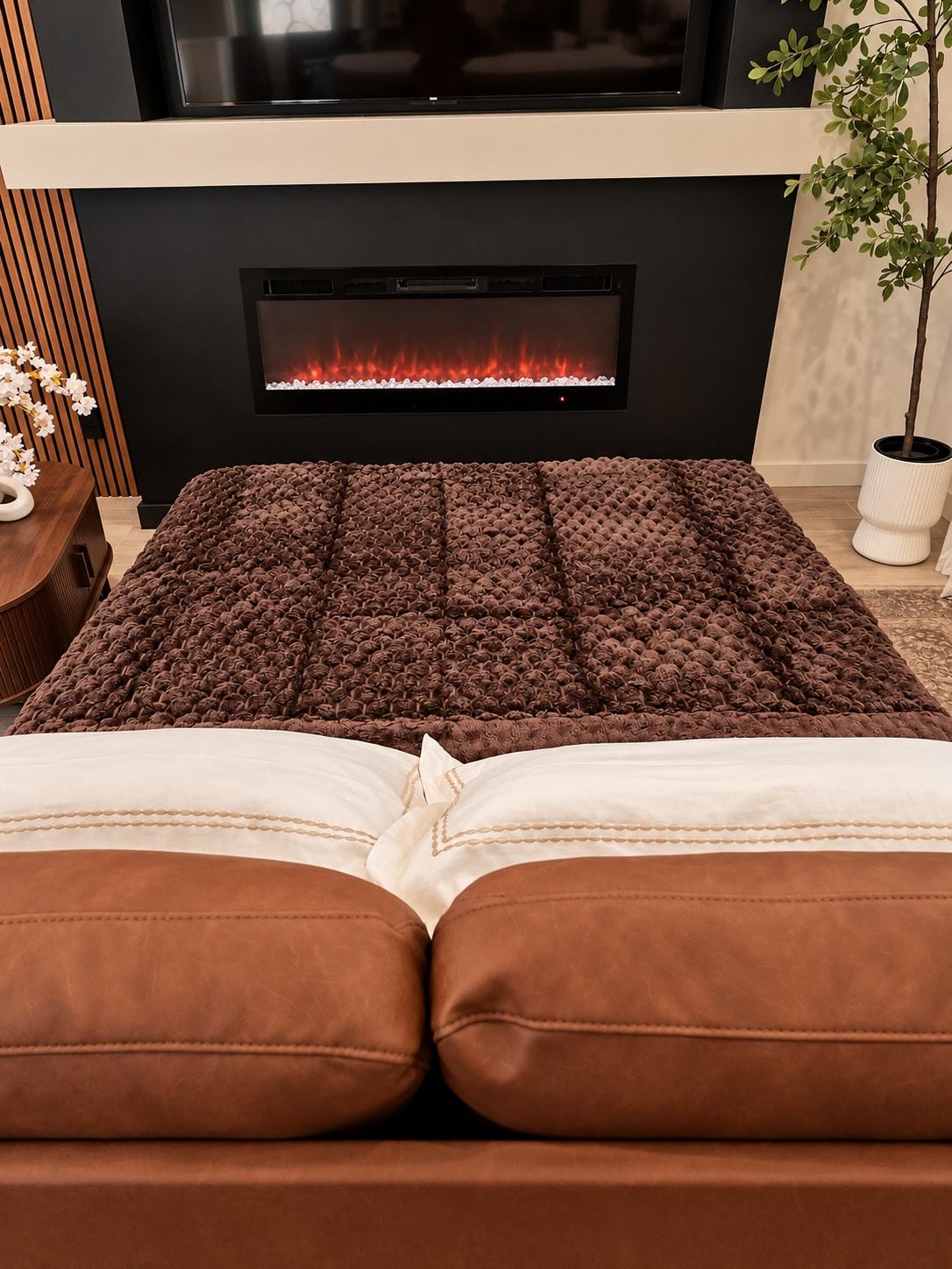 Sofa bed made up in front of the lit fireplace