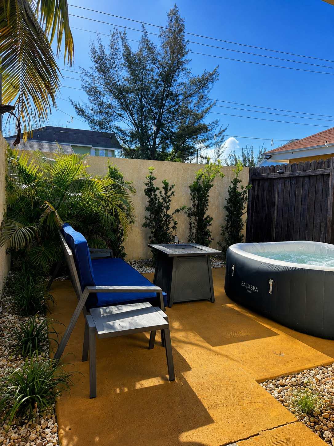 Garden lounge with jacuzzi and fire table by day