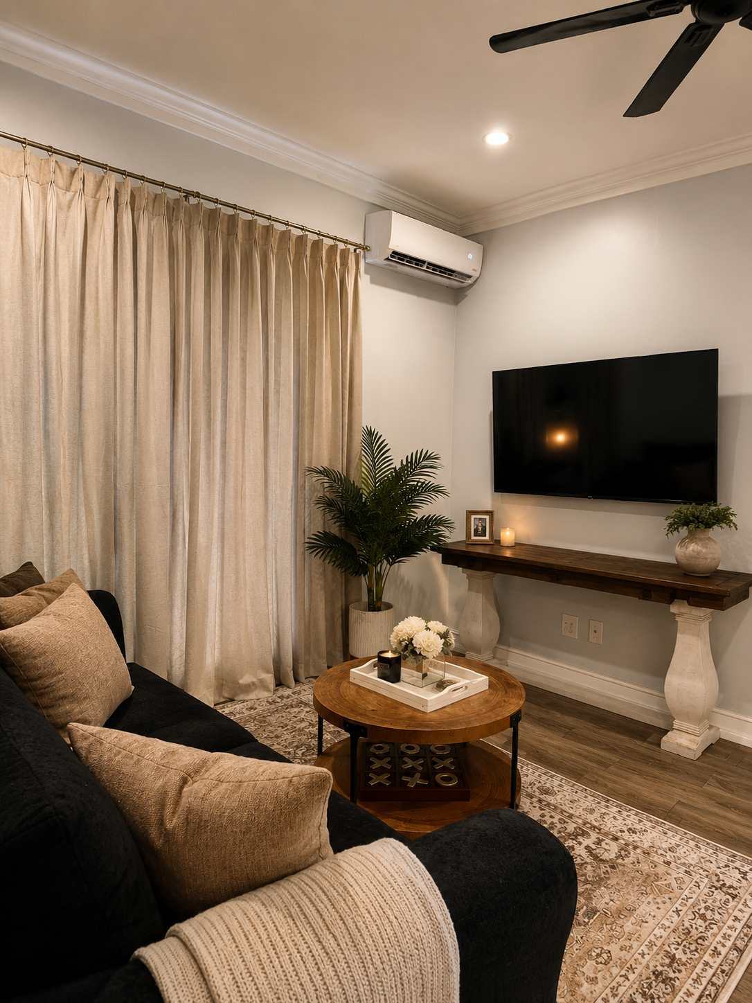 Living room with black sofa, round coffee table and smart TV