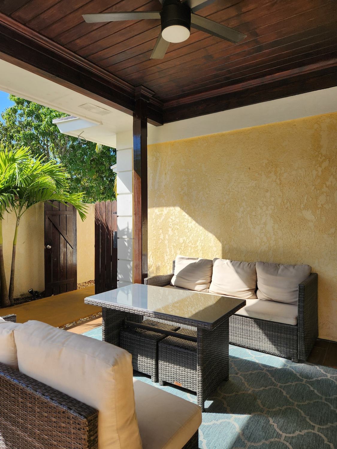 Covered patio with wicker sofas and dining table