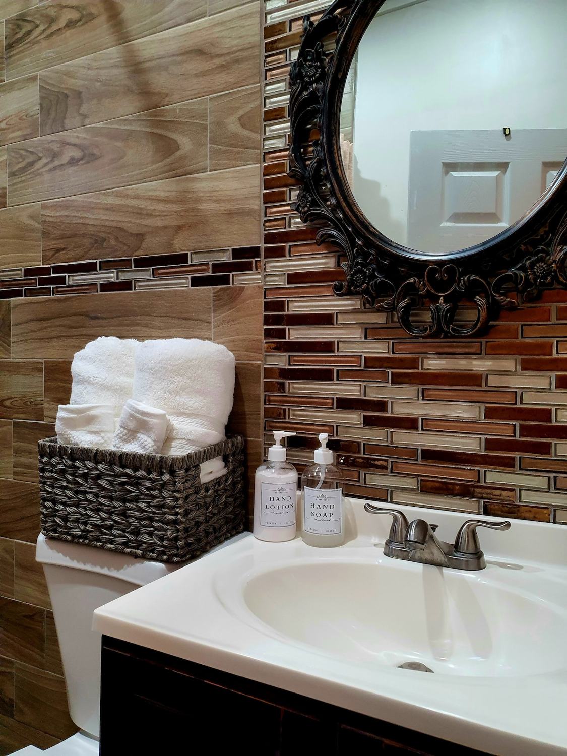 Vanity with rolled towels and ornate mirror
